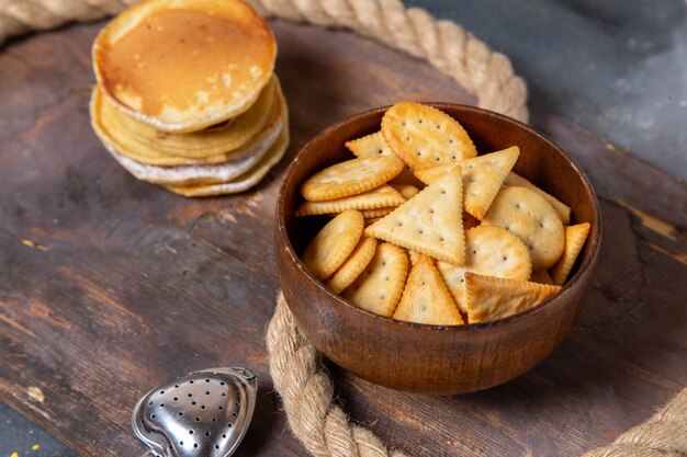 Panqueques de vista frontal con patatas fritas junto con cuerdas en el escritorio de madera