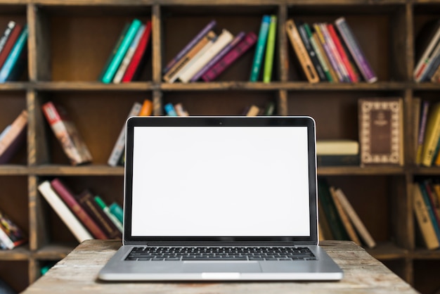 Pantalla abierta portátil en el escritorio de madera en la biblioteca