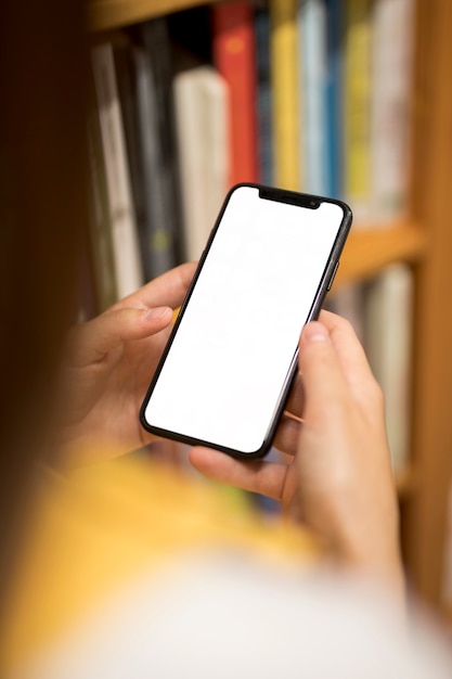 Pantalla en blanco del teléfono inteligente en manos femeninas