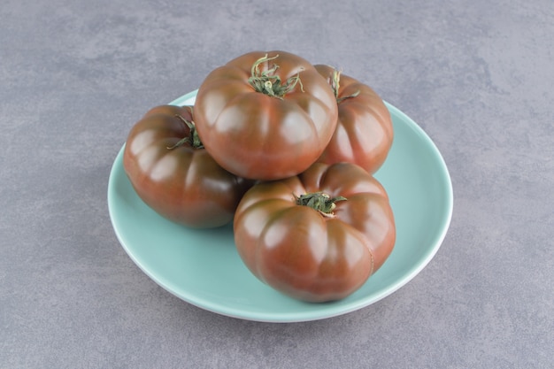 Una pantalla de tomate en el plato, sobre la superficie de mármol.