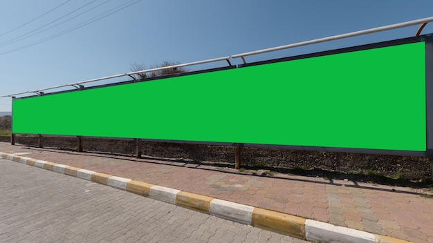 Pantalla verde larga para anuncios al costado de una carretera, un excelente espacio para su texto