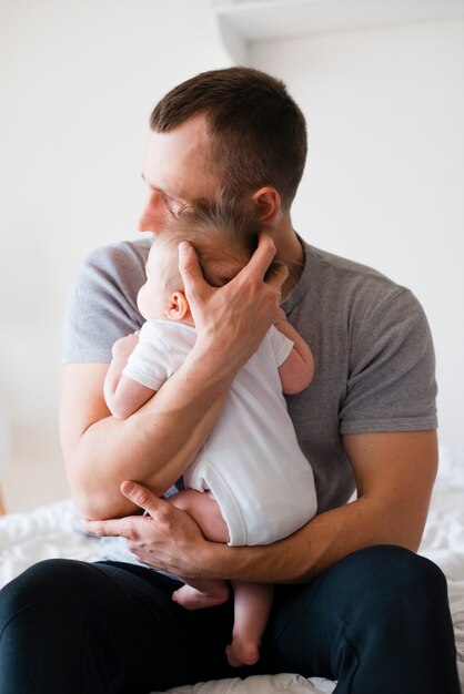 Papá abrazando al bebé con suavidad y cuidado.