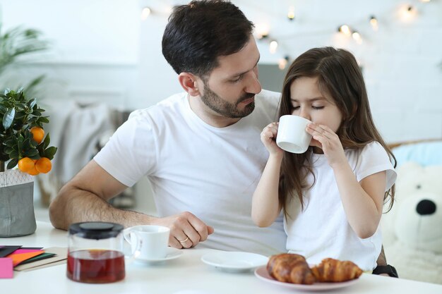 Papá e hija desayunando en la cocina