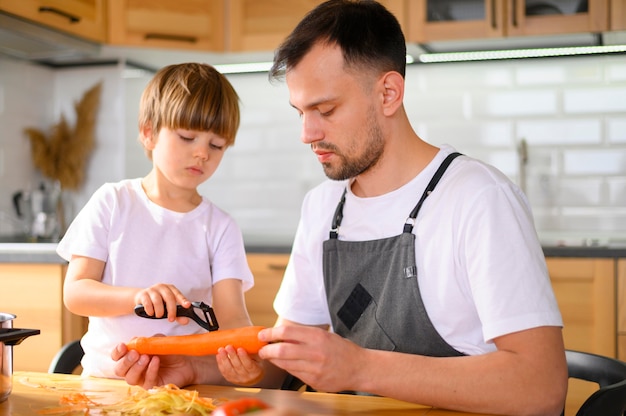 Papá e hijo pelando una zanahoria