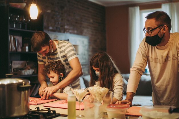 Papá e hijos cocinan pasta en una clase magistral de gastronomía