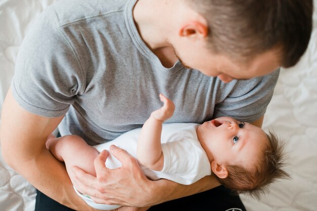 Papá encantador que sostiene al bebé lindo