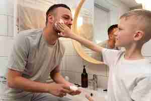 Foto gratuita papá enseñando a su hijo a afeitarse