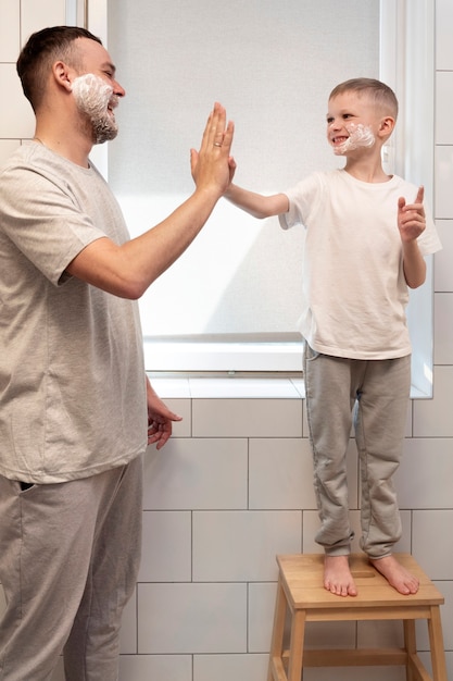 Foto gratuita papá enseñando a su hijo a afeitarse