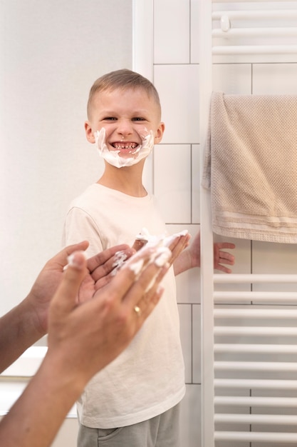 Foto gratuita papá enseñando a su hijo a afeitarse