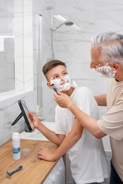 Foto gratuita papá enseñando a su hijo a afeitarse