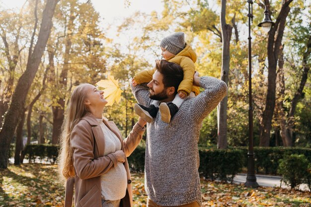 Papá feliz y mamá con bebé al aire libre