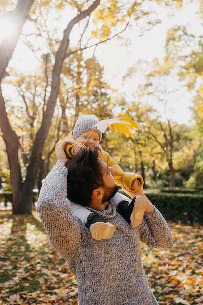 Foto gratuita papá feliz con su bebé afuera