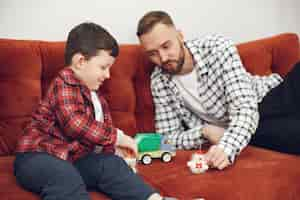 Foto gratuita papá guapo con niño en el sofá