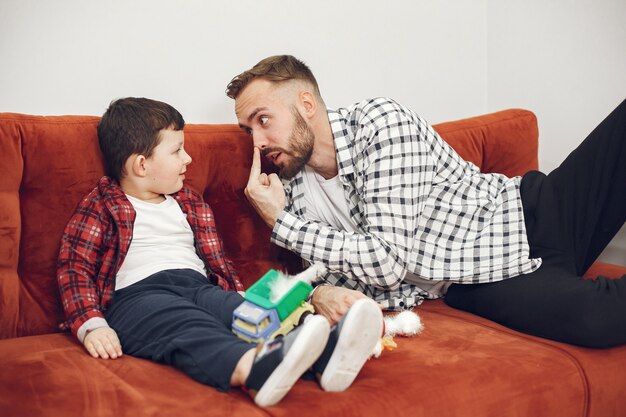 Foto gratuita papá guapo con niño en el sofá