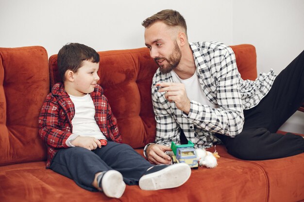 Papá guapo con niño en el sofá