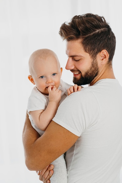 Papá guapo sosteniendo a su bebé