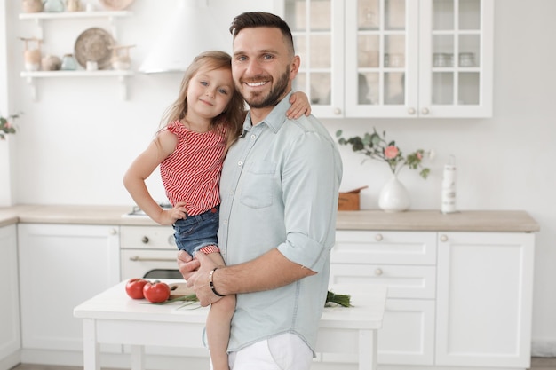 papá con una linda hija sonriente en el interior de la cocina