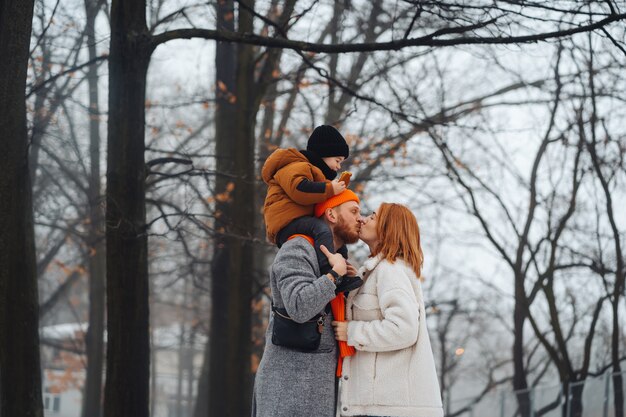 Papá mamá y bebé en el parque en invierno