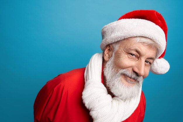 Papá Noel barbudo con sombrero rojo y pañuelo blanco en estudio