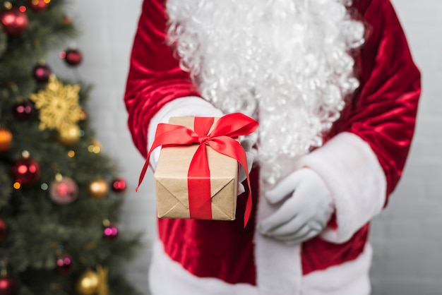 Papá Noel con caja de regalo en la mano.