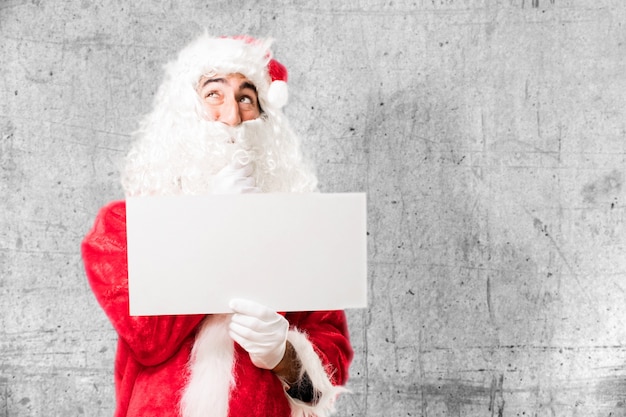 Foto gratuita papa noel con un cartel blanco