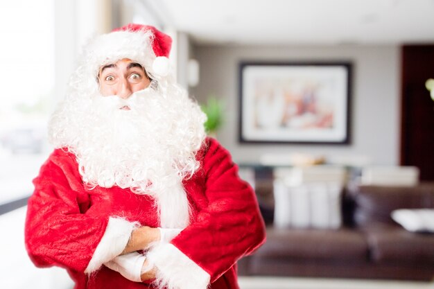 Papa noel en una casa con los ojos muy abiertos