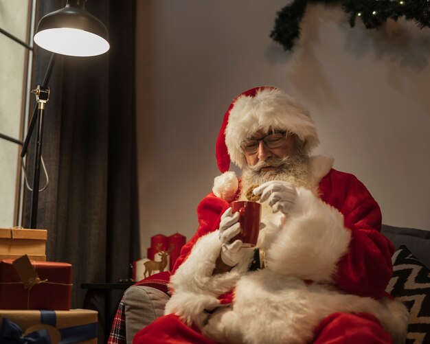 Papá Noel con un chocolate caliente y una galleta