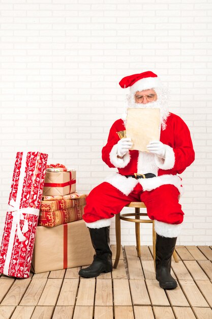 Papá Noel concentrado en leer carta de navidad.