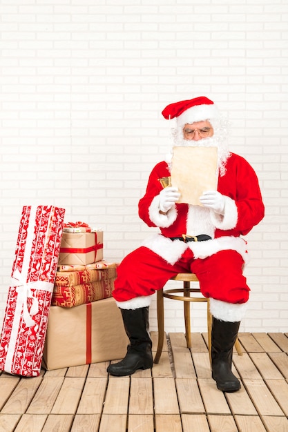 Papá Noel concentrado en leer carta de navidad.