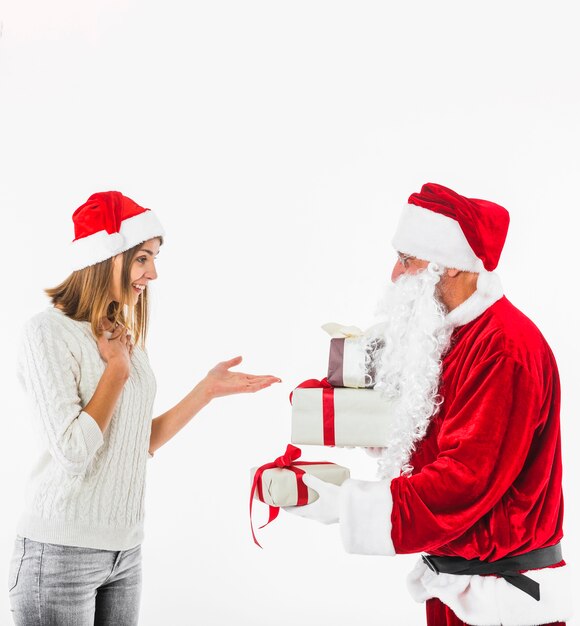 Papá Noel dando caja de regalo a mujer joven