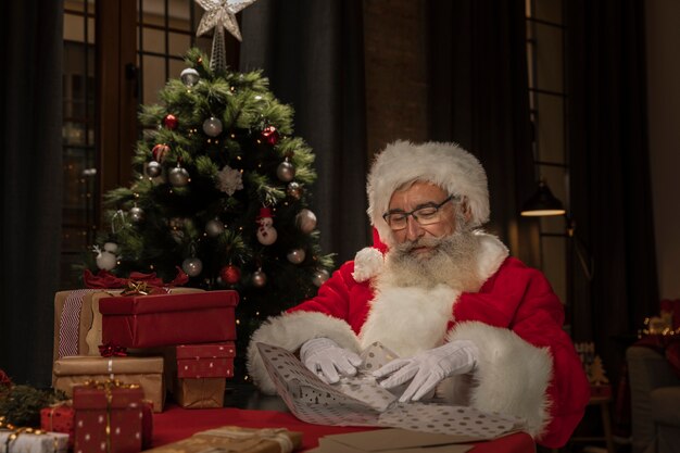 Papá Noel envolviendo regalos