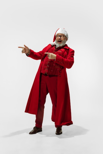 Papá Noel con estilo moderno en traje rojo de moda aislado en blanco