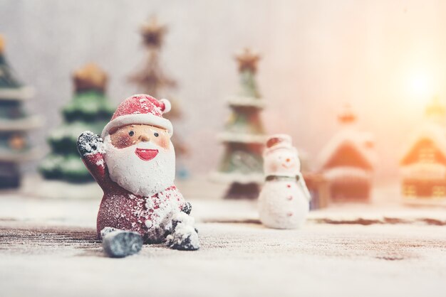 Papá noel feliz con muñeco de nieve de fondo