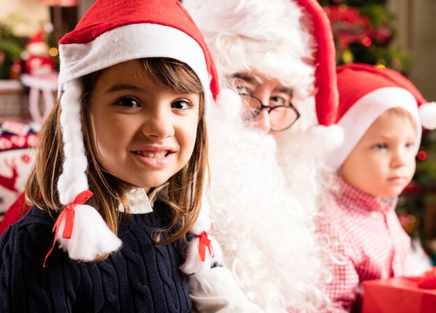 Papa noel con un niño y una niña en sus piernas