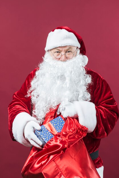 Papá Noel recibiendo caja de regalo de saco grande