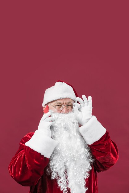 Papá Noel en ropa roja hablando por teléfono