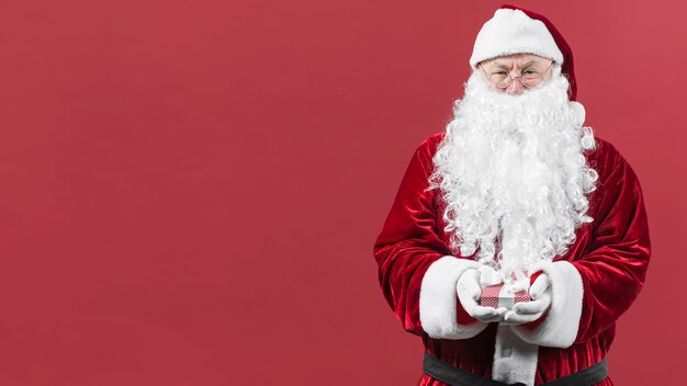 Papá Noel en sombrero con caja de regalo pequeña