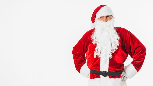 Papá Noel en el sombrero de pie con las manos en las caderas