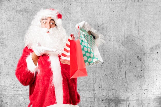 Papá noel sorprendido con tres regalos navideños