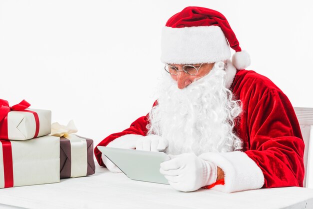 Papá Noel con tableta en la mesa