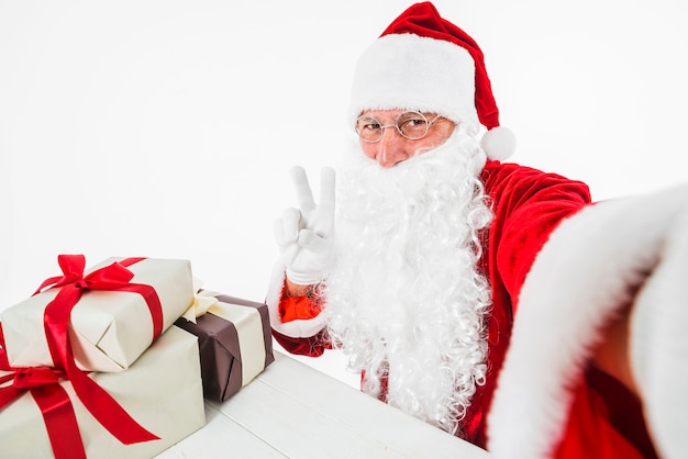 Foto gratuita papá noel tomando selfie mostrando gesto de paz