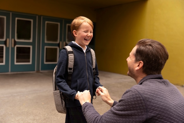 Papá paseando a su hijo el primer día de clases.