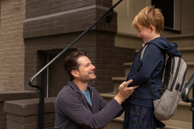 Papá paseando a su hijo el primer día de clases.