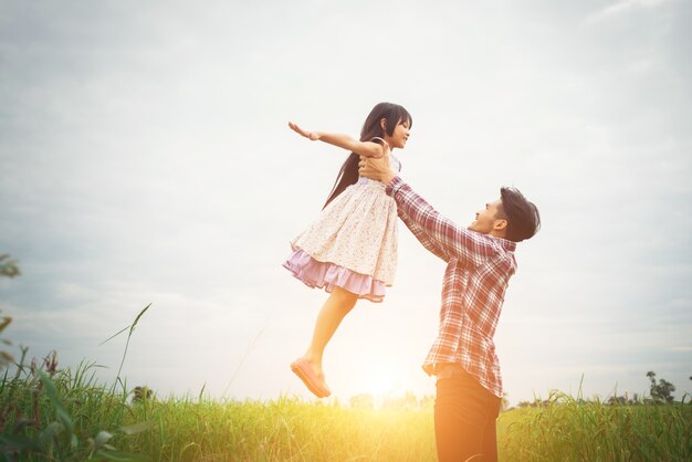 Papá que lleva a su hija con la naturaleza y la luz solar, el disfrute