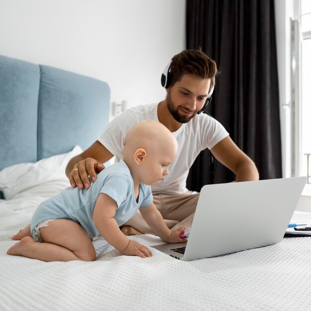 Papá trabajando desde casa durante la cuarentena con el niño