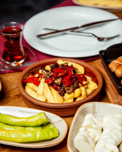 Papas fritas adornadas con berenjenas fritas y rodajas de pimiento