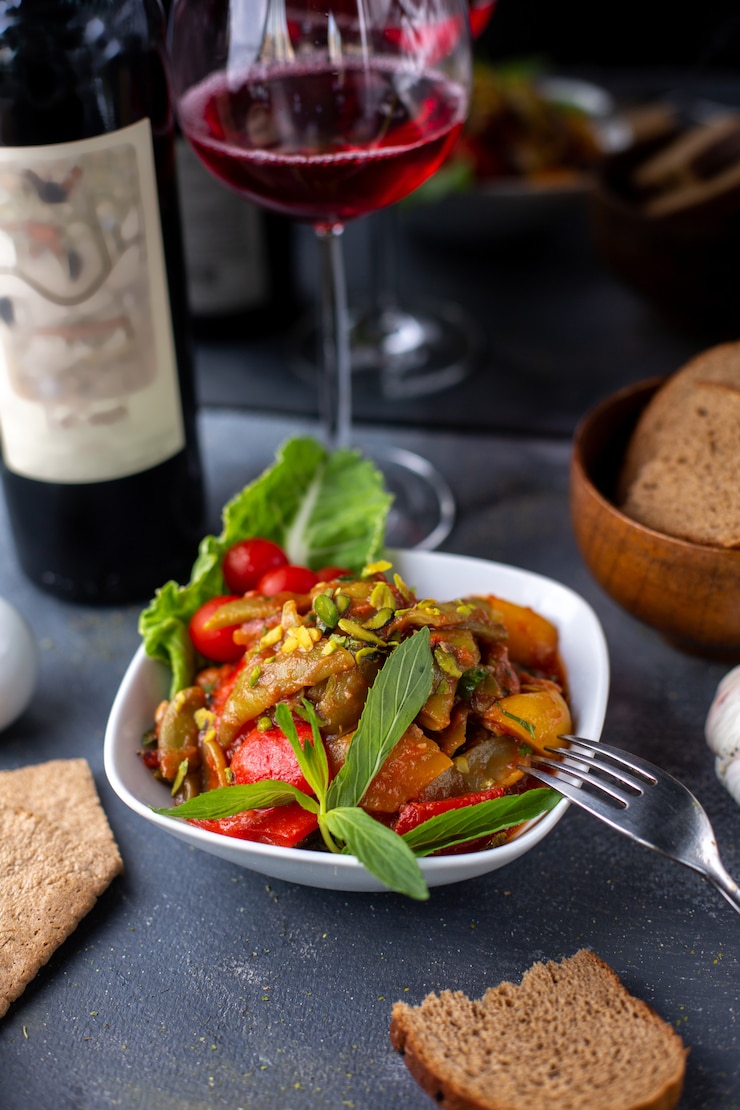 Foto gratuito papas fritas junto con ensalada de vegetales frescos y vino tinto en escritorio gris