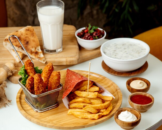 Papas fritas y nuggets de pollo rebozados en una tabla de madera