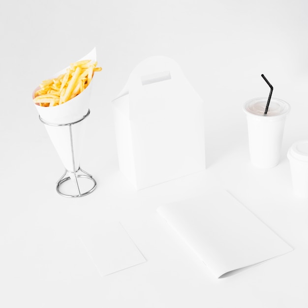 Foto gratuita papas fritas con un paquete de alimentos y una taza de eliminación sobre fondo blanco