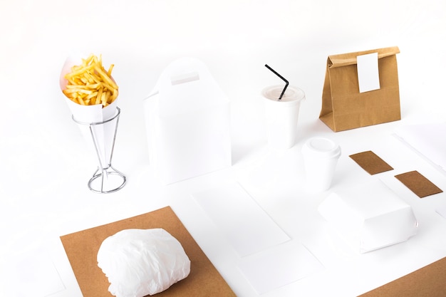 Papas fritas; paquete; Hamburguesa y maqueta de vaso desechable sobre fondo blanco